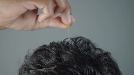 applying hair oil to scalp