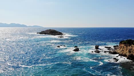 Wunderschöne-Türkisfarbene-Wellen,-Die-Felsklippen-Am-Strand-Von-Jerusalem,-Erisos,-Griechenland-Treffen---Luftdrohnenaufnahme