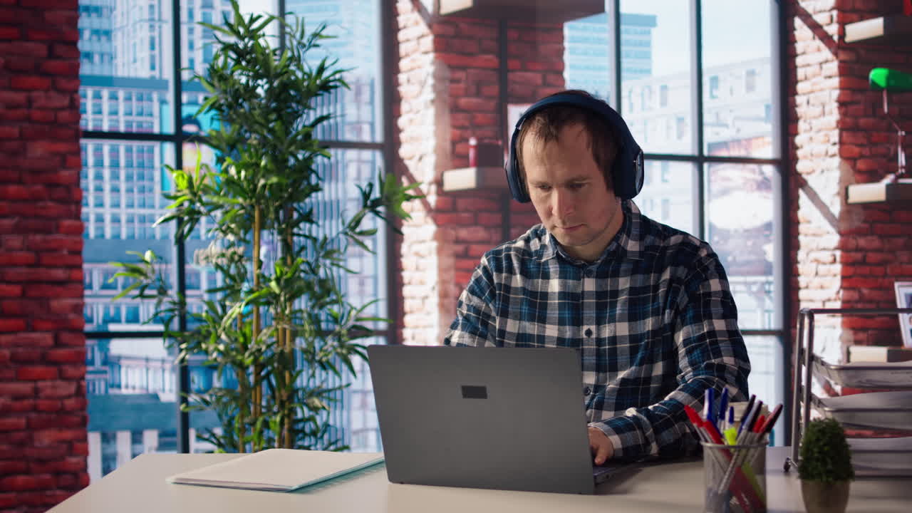 freelancer en la oficina de casa sentado en el escritorio frente a la computadora portátil, contestando llamadas telefónicas