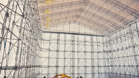 panning tilt up shot of a large tent structure held up by scaffold