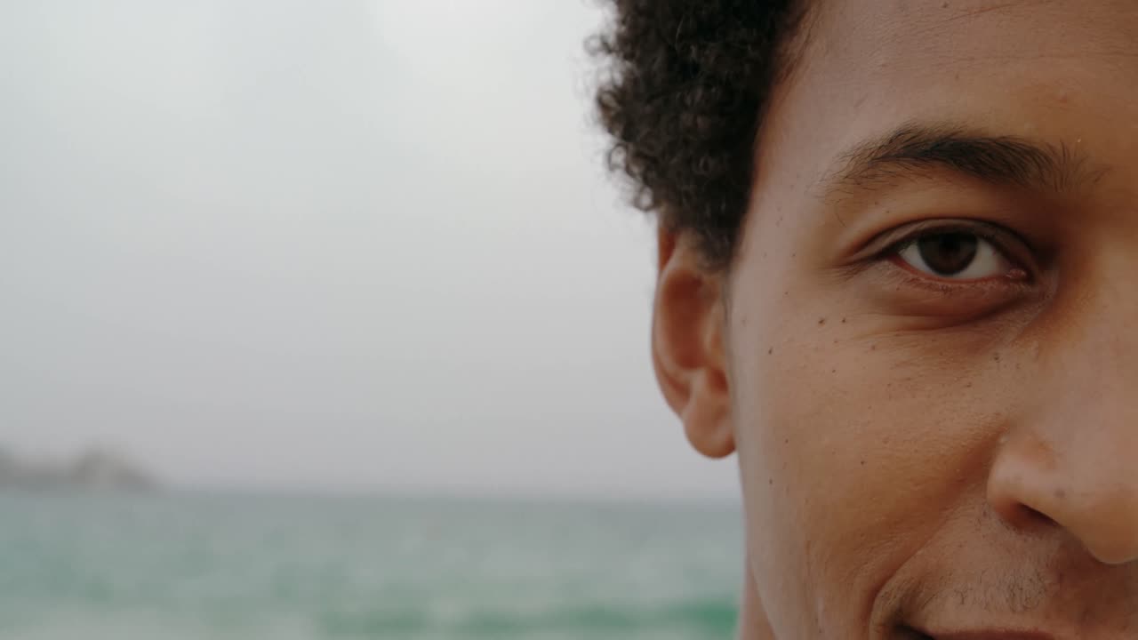 primer plano de un hombre afroamericano de pie en la playa 4k