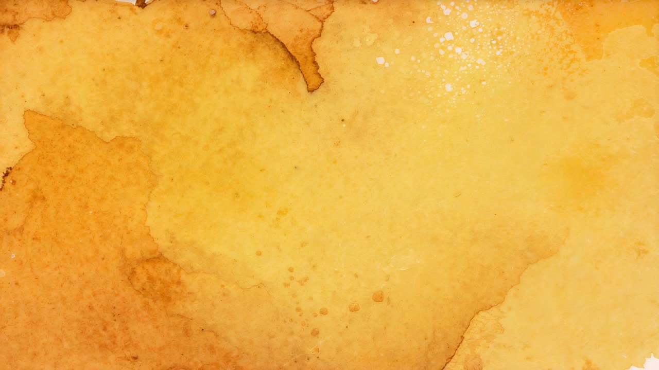 Câmera gravando um papel em estúdio, documentando lavagem amarela, manchas marrons e gotas brancas