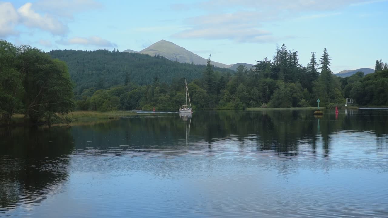 The Beautiful Scenery Of Caledonian Canal In Scotland With Glorious Trees and Bright Blue Sky - Wide Shot