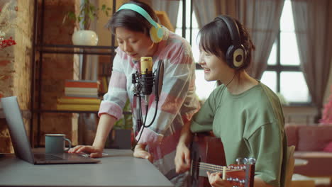 two asian women recording music together at home