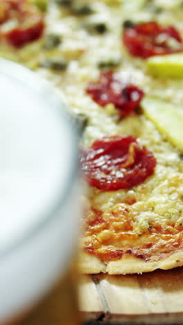 una deliciosa pizza con un vaso de cerveza
