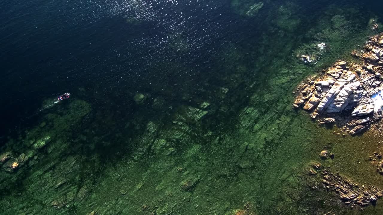 Aerial Birds Eye View Over Turquoise Water Off Rocky Coastline In Aguino. Dolly Forward