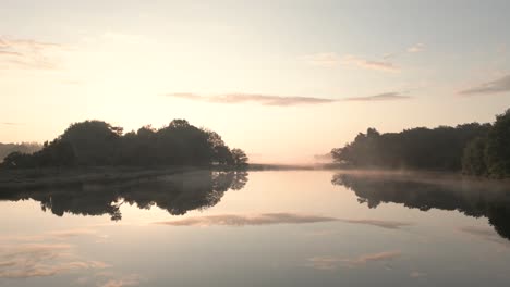 misty sunrise over a lake and forest