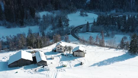 excellent aerial view of a car driving past homes in wintry landwasser, switzerland