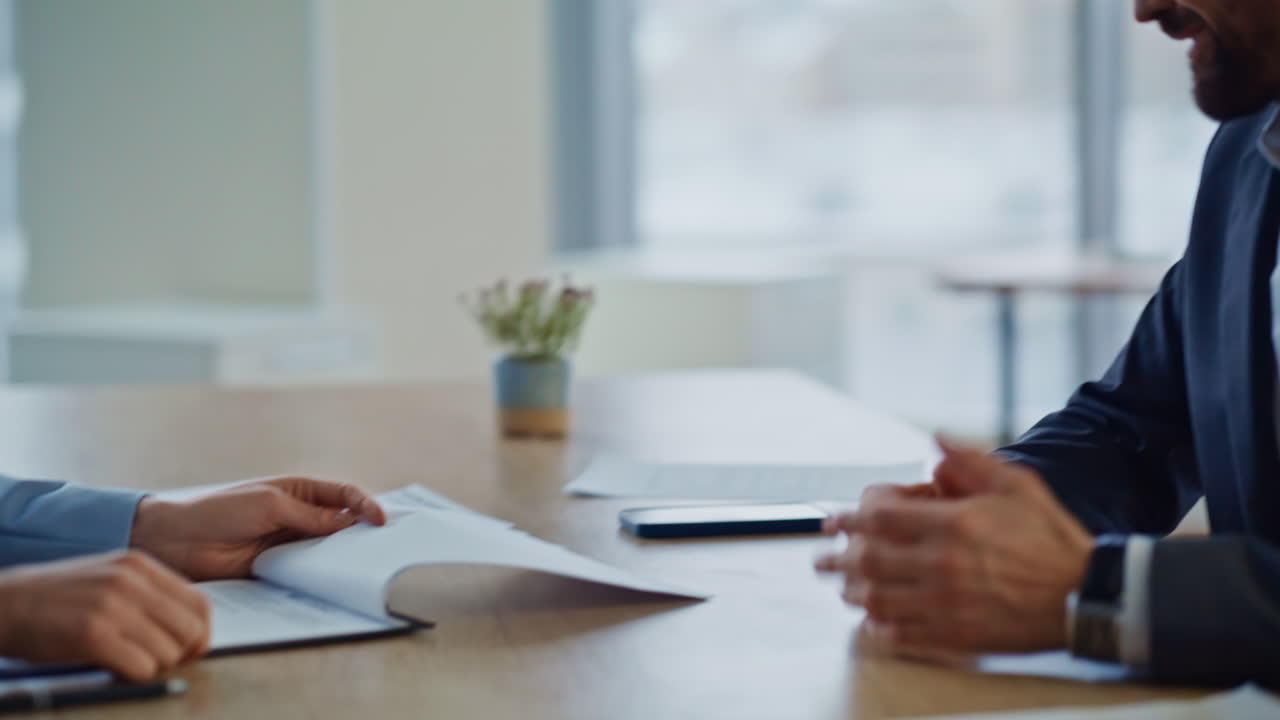 Closeup positive businessman talking with woman indoors. Employees shaking hands