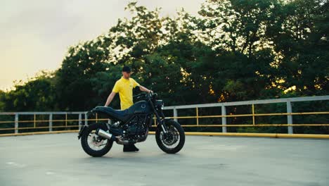 A-motorcycle-driving-instructor-in-a-yellow-t-shirt-drives-motorcycles-and-sets-it-up-on-the-road.-Preparation-for-training-students-in-a-motorcycle-school