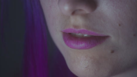 close up of a girl's purple lips in a dark room