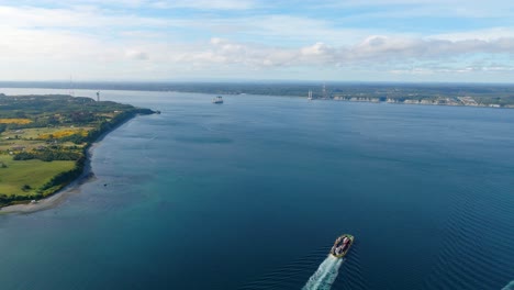 Aerial-View-Of-Ferry-Crossing-Chacao-channel-With-Construction-Of-Bridge-Between-Mainland-And-Big-Island-of-Chiloé-In-background