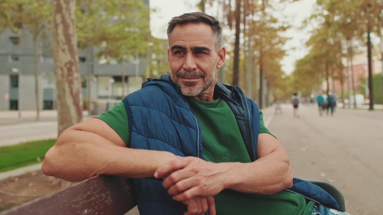 Retrato de un hombre sentado en un banco en un parque