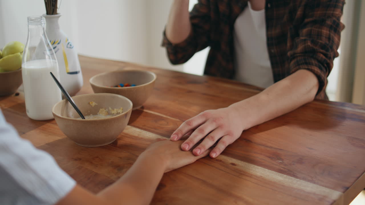 Gentle husband talking wife in home kitchen. Closeup man hand holding woman