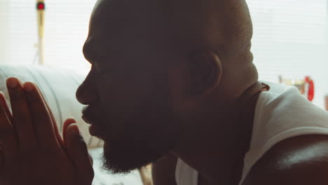 african american man saying prayers at home