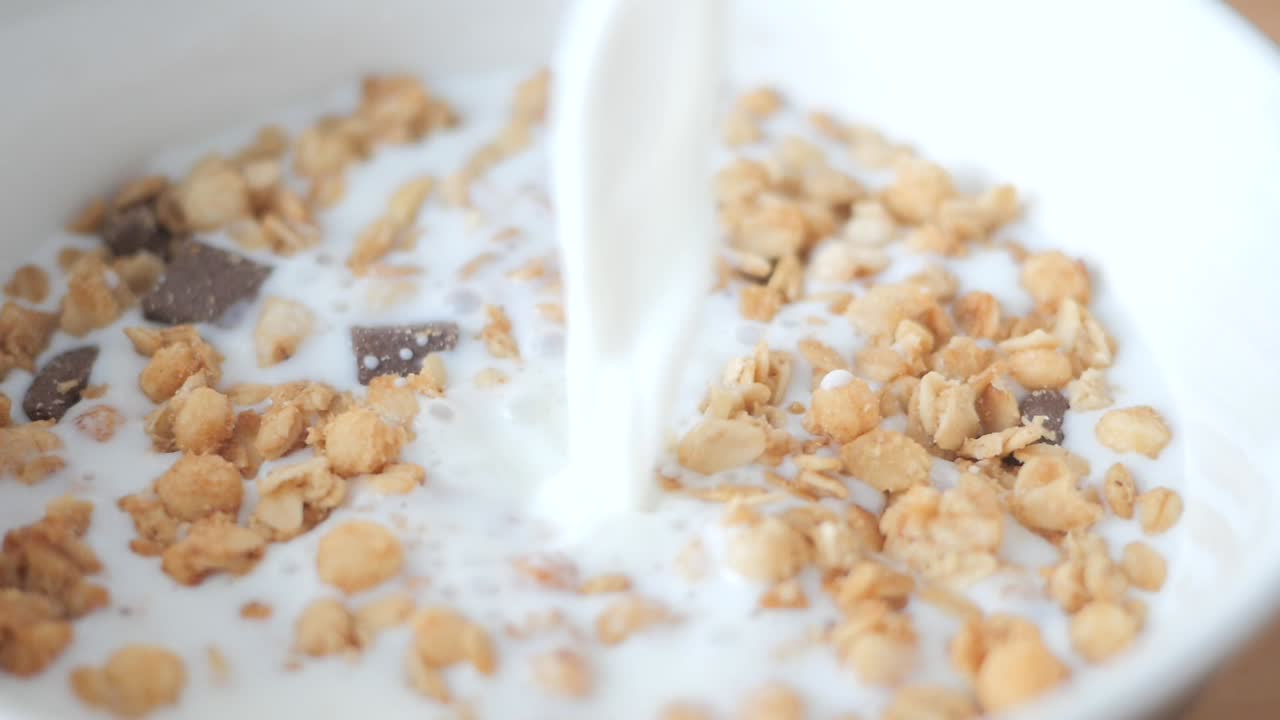 Versare il latte in una ciotola di cereali granola