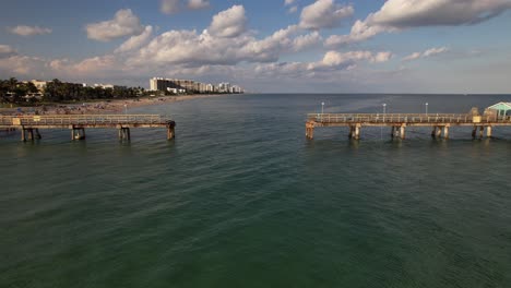 A-low-altitude-aerial-view-over-the-Atlantic-Ocean-off-a-beach-in-Fort-Lauderdale,-Florida-on-a-beautiful-day-with-blue-skies