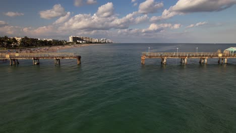 una vista aérea de baja altitud sobre el océano atlántico frente a una playa en fort lauderdale, florida en un hermoso día con cielos azules