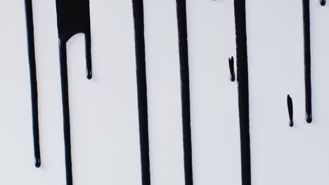 primer plano de formas de pintura negra sobre fondo blanco con espacio de copia, cámara lenta