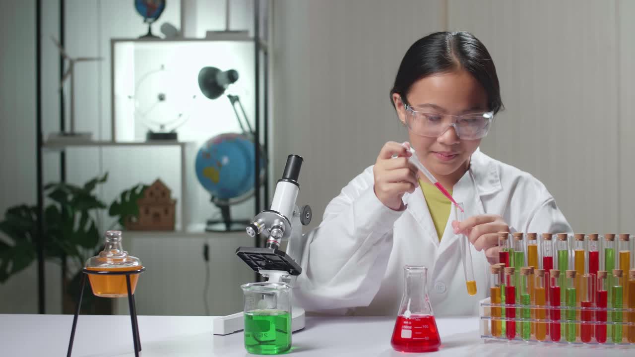 Young Asian Scientist Girl Mixes Chemicals In Test Tube. Child Learn With Interest