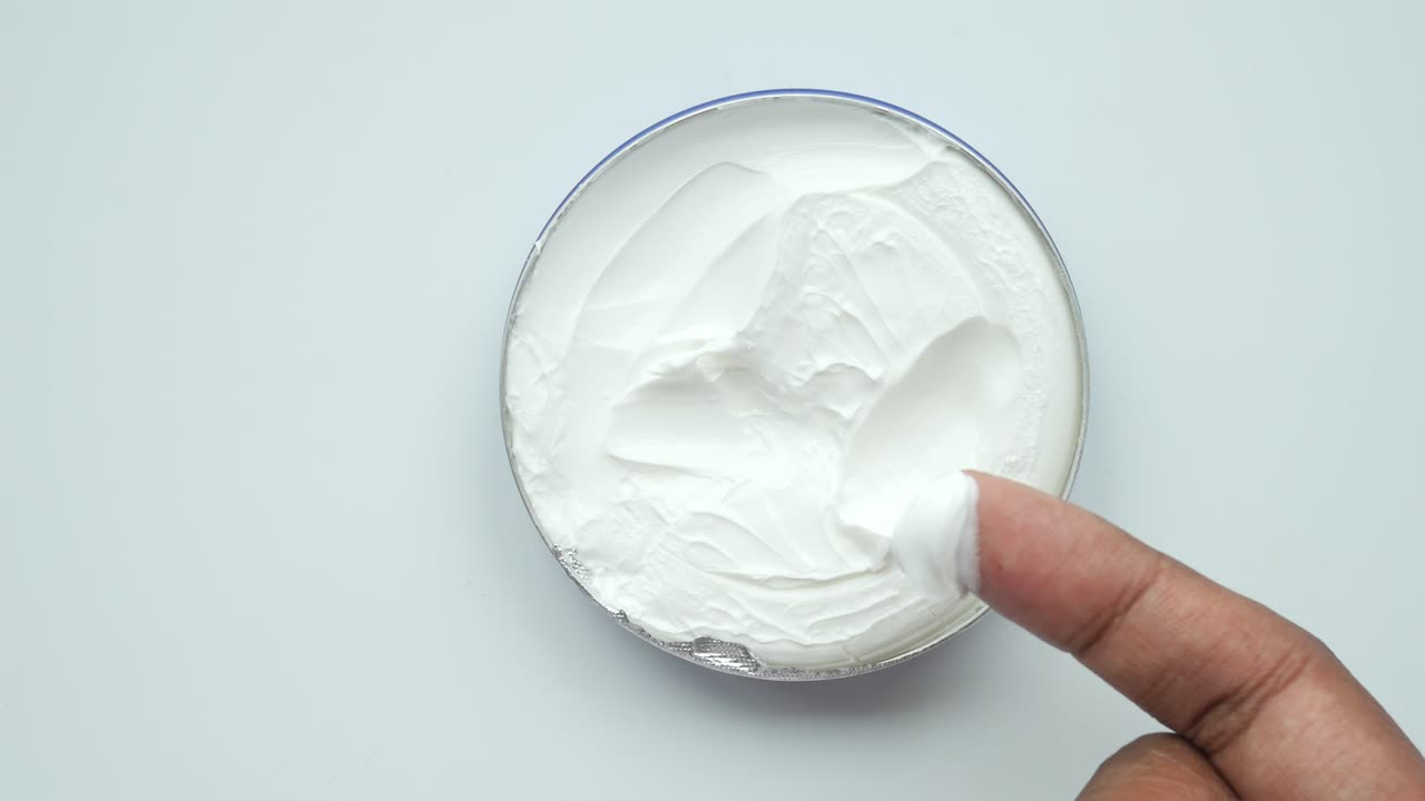 la aplicación de la crema de un frasco
