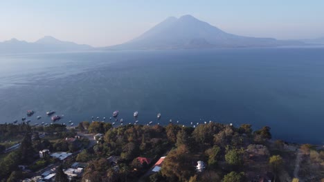 aerial: atitlan volcano visible across lake from jaibalito, guatemala