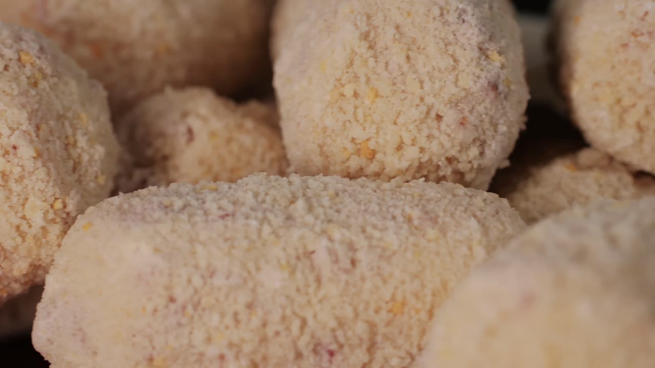 Portuguese croquettes on black background close-up macro. Breaded croquette of fish, potatoes and ham. Man cooking spanish food . High quality 4k footage