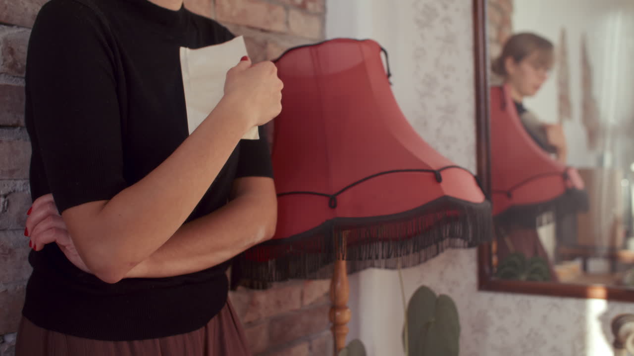 Woman Holding Paper in Front of Red Lamp