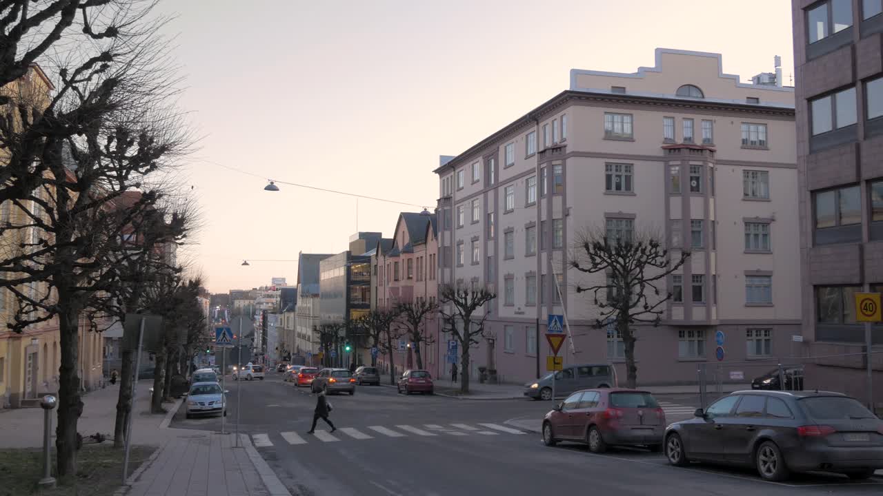 Woman crossing a street in the city center. Mid sized city. Wide angle shot