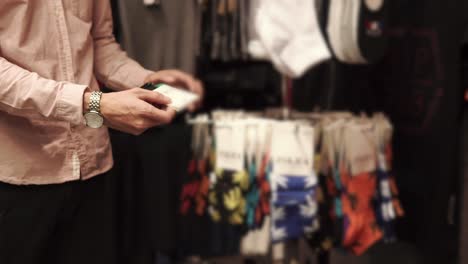 hombre comprando calcetines en una tienda de ropa