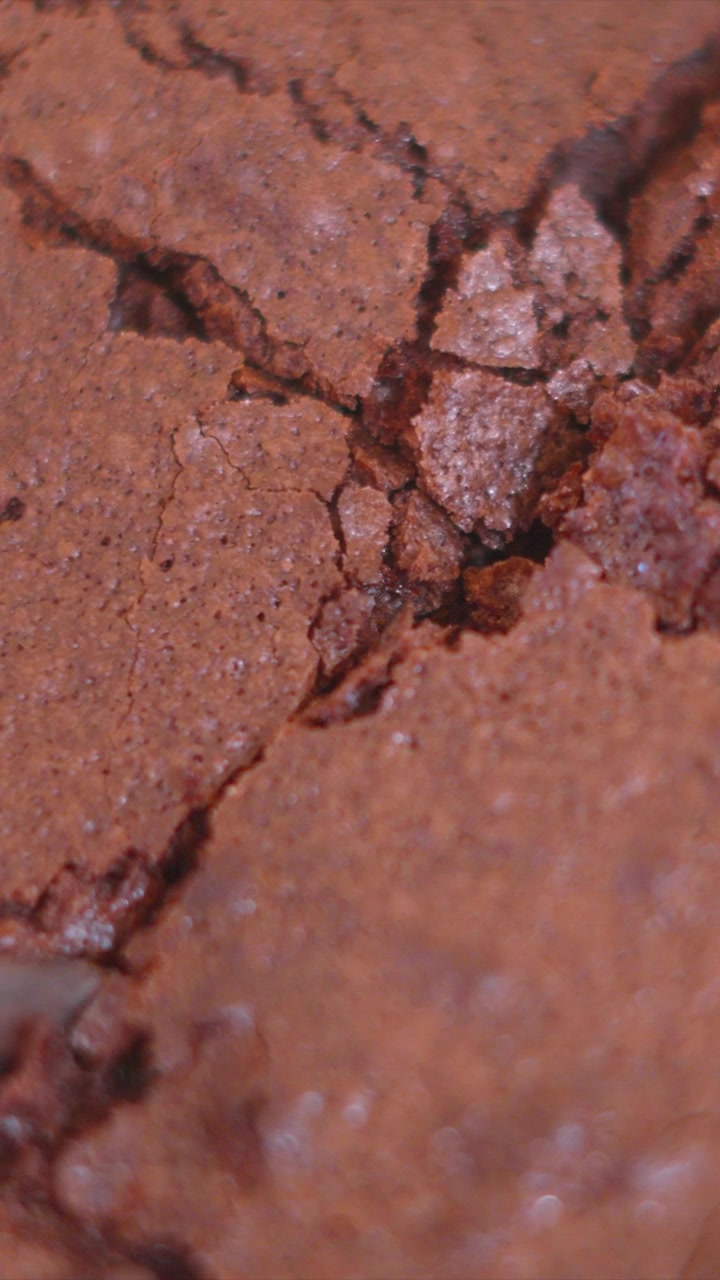 Vertikální video. Detail nože, který láme a krájí lahodný čokoládový brownie