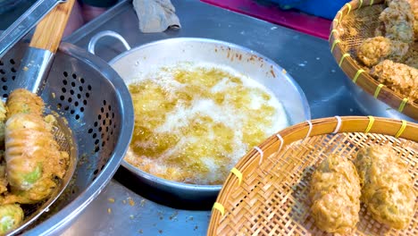 cooking deep fried rice snacks at bangkok floating market stall