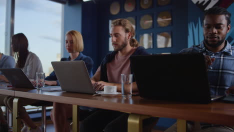 Multiracial-group-of-people-chatting-in-coworking.-Workers-speaking-in-office