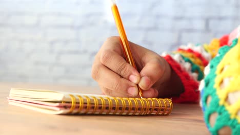 persona que escribe en un cuaderno