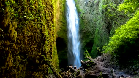 dolly out of hidden mili mili waterfall streaming into natural pool surrounded by dense green vegetation, coñaripe, chile