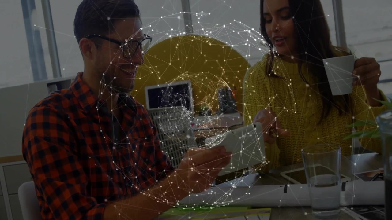 Mand holder tablet og kvinde holder krus, arbejder ved teknisk skrivebord med glødende digitalt netværksoverlay.