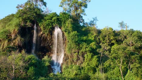 The-natural-waterfall-that-flows-down-the-mountain-is-lit-by-the-evening-sun