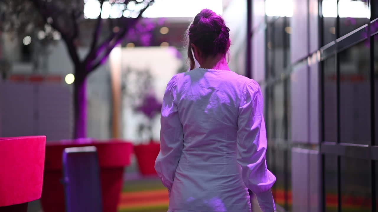 Woman in white dress posing in Cannes in purple lights, France