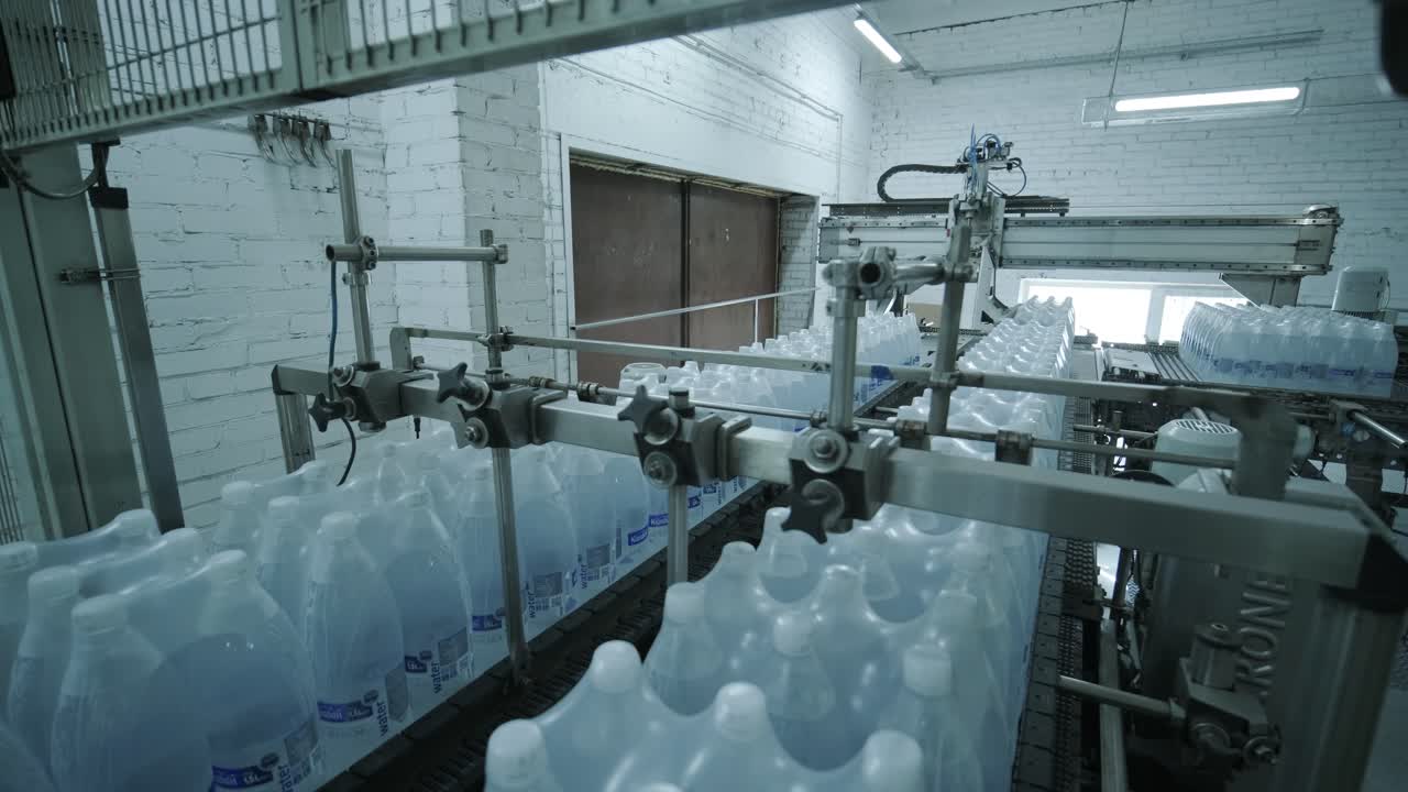 máquina moderna de ataduras y transporte para la línea de envasado en la planta de bebidas