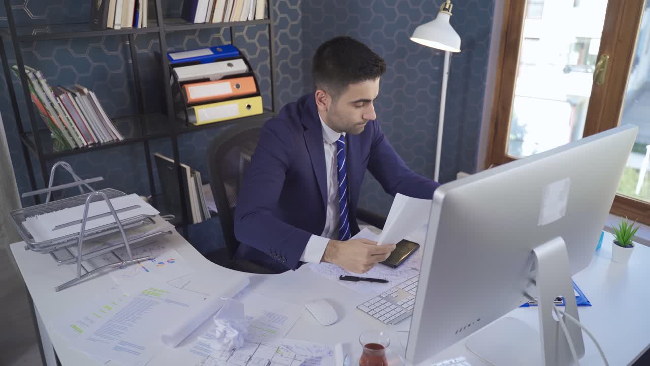 y un hombre de negocios ocupado trabajando en un escritorio en la oficina.