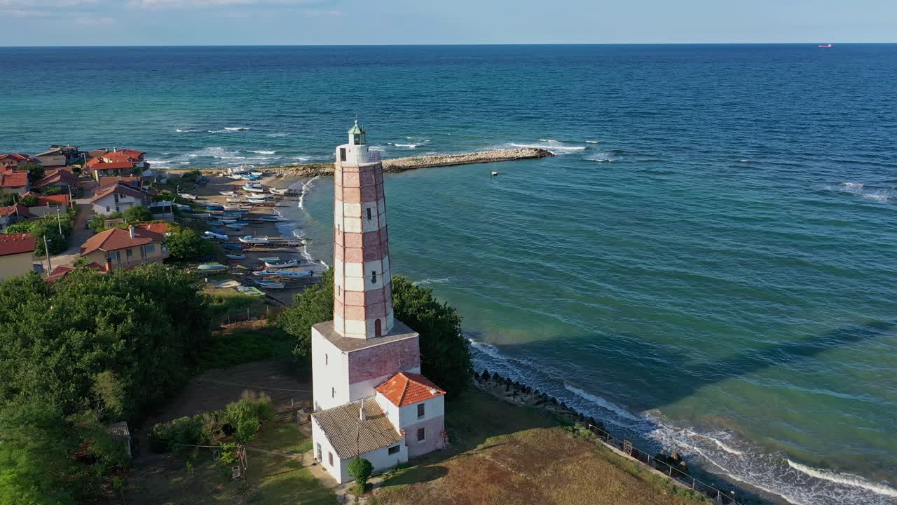 un antiguo faro cerca del mar con olas golpeando la orilla