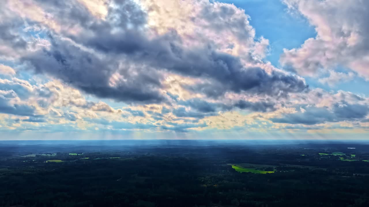 Majestic cloud formation with sunburst over wild forest, time lapse
