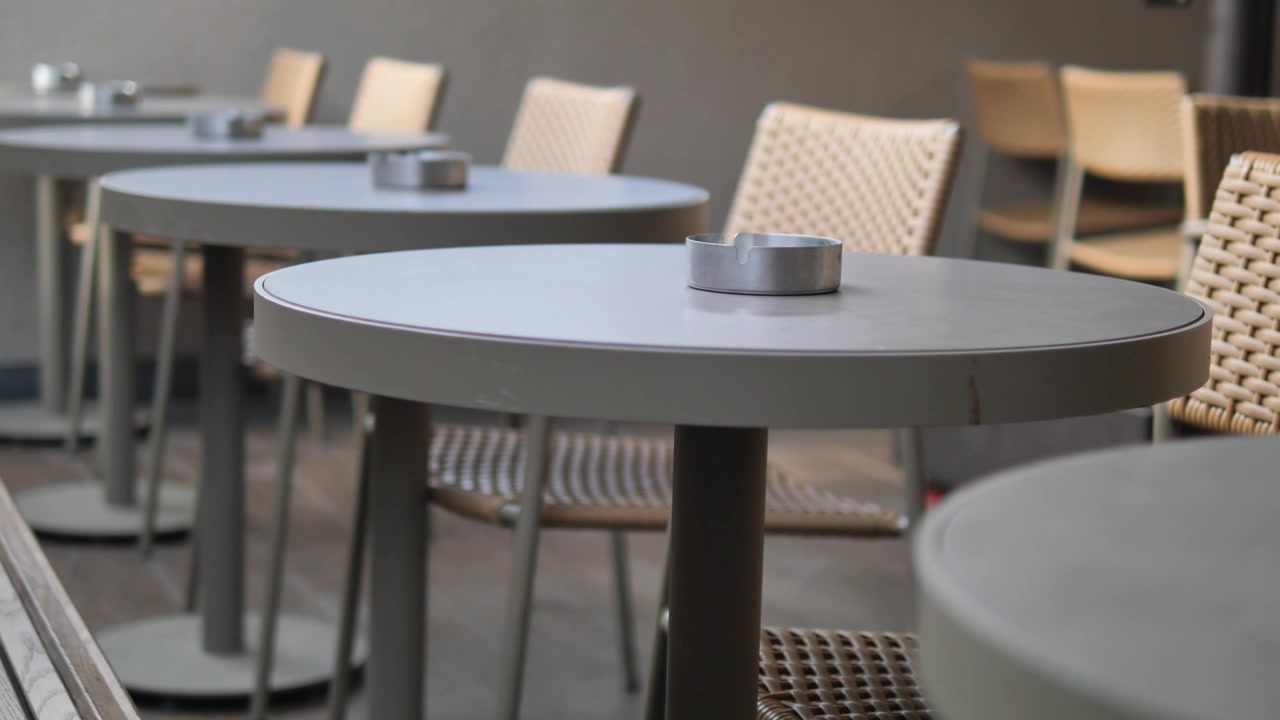 Empty Outdoor Cafe Tables with Wicker Chairs