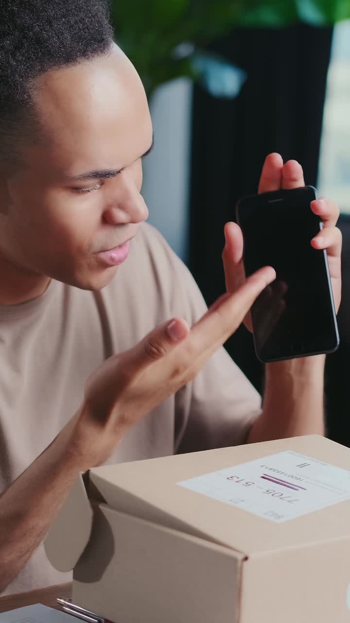 Young charismatic expressive african american man blogger unboxes phone