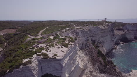 aerial shot moving in on lighthouse phare de pertusato, sitting on white coastal cliffs near bonifacio