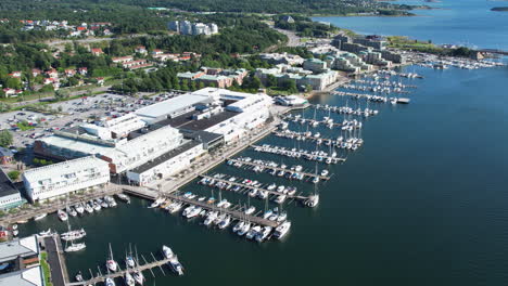 pull out drone shot of stenungsund hamn with boats and blue water in the day in bohuslan, sweden