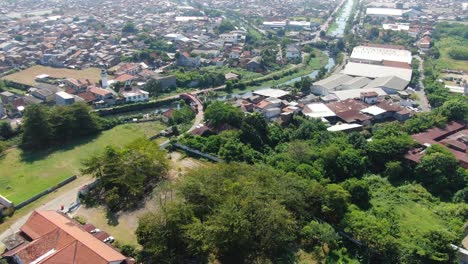 Small-river-flowing-through-city-of-Semarang,-aerial-drone-view-of-suburbs-area