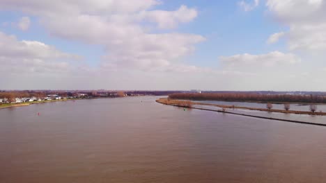 aerial flying over oude maas in barendrecht with blue sky and clouds in view