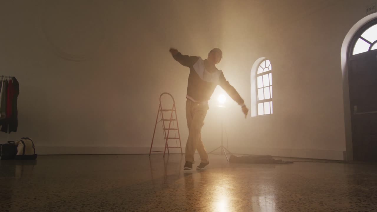 Portrett av birasial mannlig danser som danser i dansestudio, sakte film