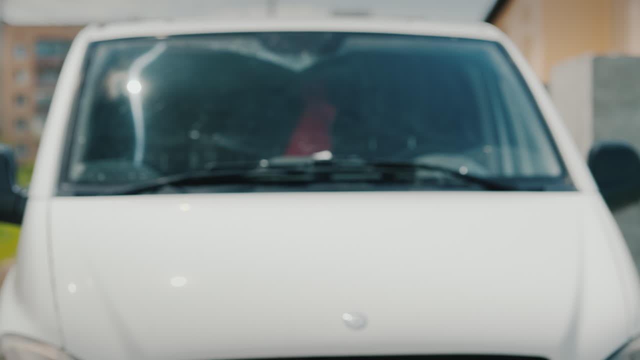 un oficial de entrega entrega bolsas de comida al cliente contra el fondo de una camioneta blanca